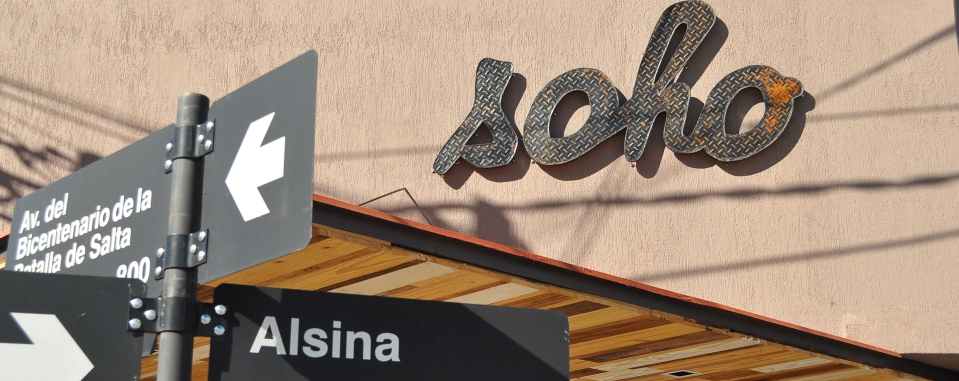 Foto del frente de Soho Bar & Resto, con carteles de las calles en primer plano
